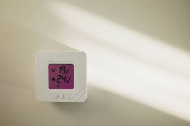 istock Close-up shot mounted on white wall, climate control showing 24.2 degrees indoors, remote air conditioner inside smart home close-up, no people. Modern technologies, the concept of a comfortable life 2060150441