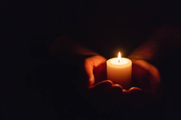 istock Hands holding burning candle in dark like a heart.Selective focus,black background.Copy space. 2060151540