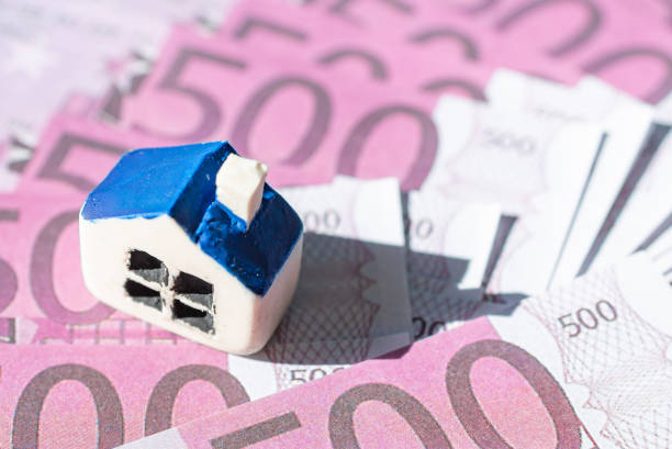 Miniature toy house placed on Euro bill banknotes. Concept for real estate costs, prices, buy or rent a house, hypothecary credit, interest.Selective focus,closeup.Blurred background and foreground. Miniature toy house placed on Euro bill banknotes. Concept for real estate costs, prices, buy or rent a house, hypothecary credit, interest.Selective focus,closeup.Blurred background and foreground. hypothecary stock pictures, royalty-free photos & images
