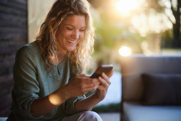 istock Happy woman text messaging on cell phone on a patio. 2060159397