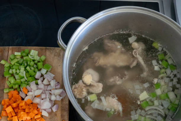 Cooking chicken stock, chicken broth slow cooking stock photo