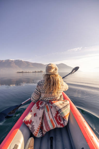 Rear view, female canoeing on spectacular mountain lake