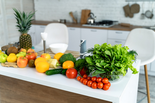 A Colorful Bounty of Fresh Fruits and Vegetables to Inspire Healthy Eating. A kitchen counter topped with lots of fresh fruits and vegetables