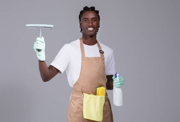 istock Smiling Black Cleaner Man In Apron Advertising Cleaning Services 2060222497