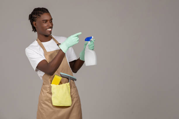 istock Cleaning Advertisement. Young Black Male Cleaner Holding Detergent Spray And Pointing Aside 2060222500
