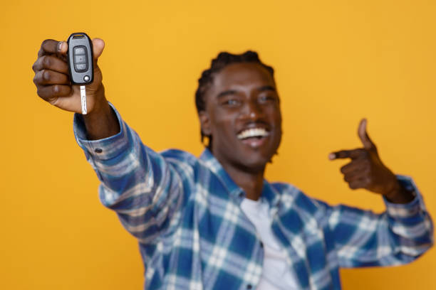 istock Happy Black Guy Showing New Car Key While Posing On Yellow Background 2060223353