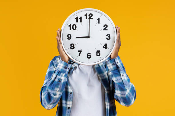 istock Unrecognizable black male holding large round clock in front of his face 2060223600