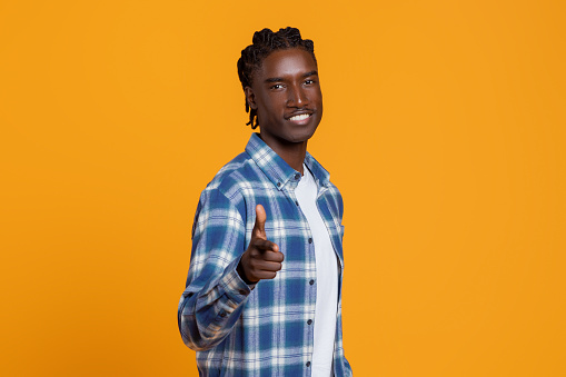 Handsome Young African American Guy Pointing At Camera With Hand, Indicating Somebody, Cheerful Black Millennial Man Saying Gotcha And Smiling, Posing Isolated On Yellow Studio Background, Copy Space