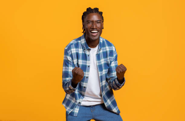 istock Cheerful young black guy celebrating success on yellow studio background 2060223624