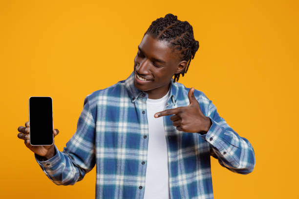 istock Check This. Cheerful Black Guy Pointing At Blank Smartphone In His Hand 2060223636