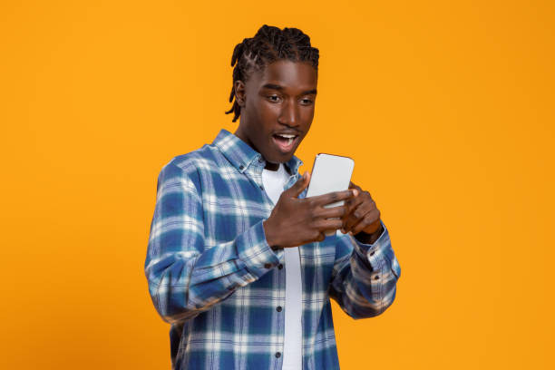istock Great App. Amazed young black man looking at smartphone screen with excitement 2060223638