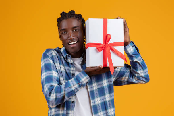 istock Happy young black man holding gift box with ribbon 2060223651