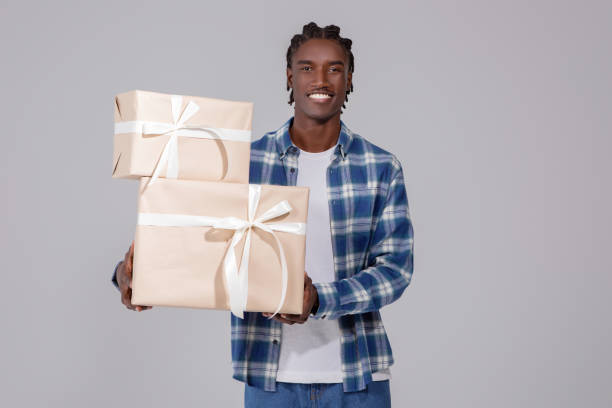 istock Celebration Time. Portrait of happy black guy holding stack of present boxes 2060223660