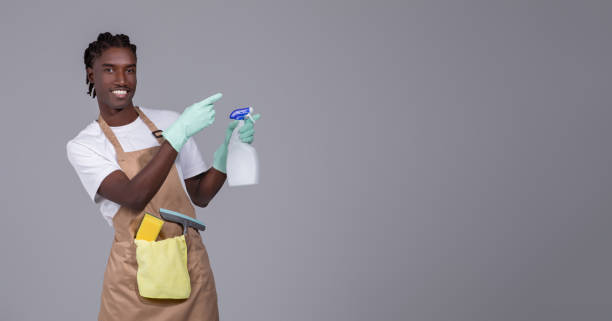istock Young handsome black cleaner guy wearing apron pointing aside at copy space 2060223662