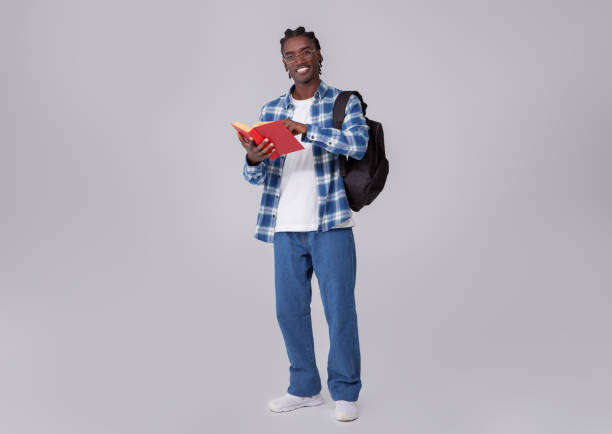istock Nerdy Young Black Student Guy With Book And Backpack On Grey Background 2060224179