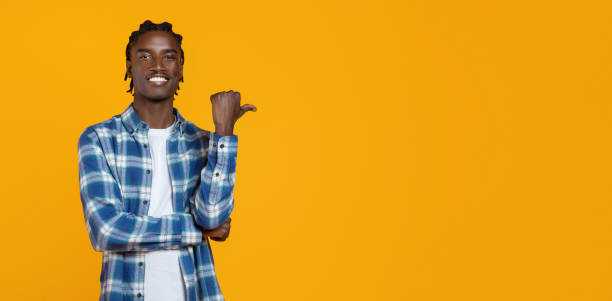 istock Handsome young black man in plaid shirt pointing aside to empty space 2060224180