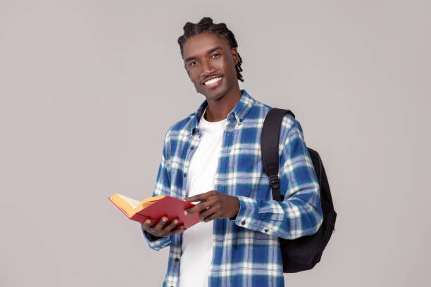 istock Education concept. Handsome african american guy with backpack and book 2060224191