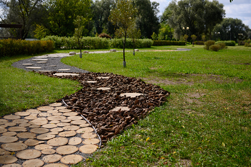 Massage tactile eco path with different textures in a city park. Prevention of flat feet, hardening, stress management.