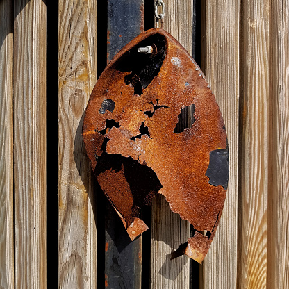 Rusty old metal sign on a wooden wall. Rustic background