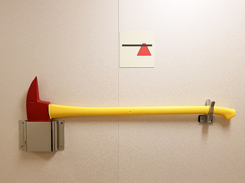 Firefighter axe and a sign on a wall in a building