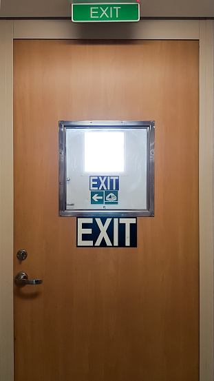 Exit sign on the door of a modern accommodation building, closeup of photo