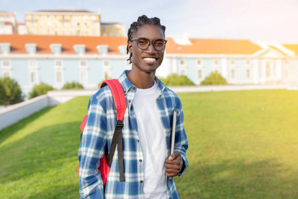 istock African American Student Guy With Backpack And Laptop Stands Outside 2060249908