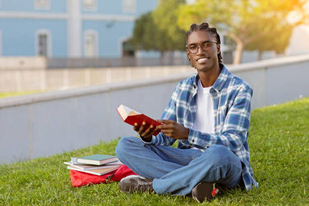 istock Happy African American student guy casually reads book outdoor 2060249961