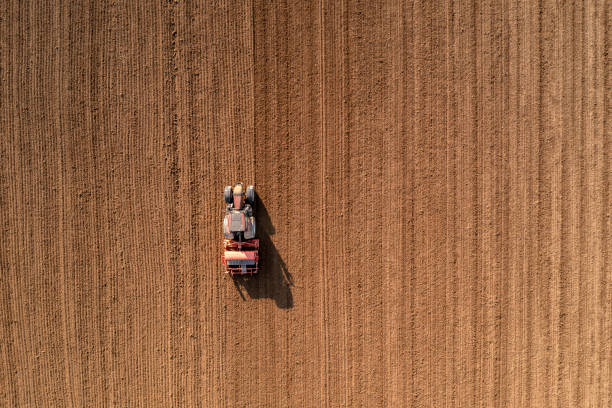 istock Red tractor sows the field, aerial view 2060255024