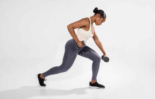 istock black lady doing strength exercises with weights over white wall 2060259945