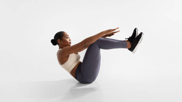 istock African American woman exercising in boat pose in white studio 2060260474