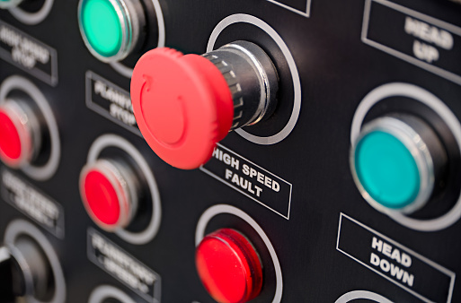 Black control panel with red and green round lamps and buttons. Abstract industrial background.