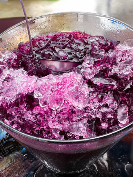 image en gros plan d’une cruche en verre recouverte de condensation avec une boisson violette de jus de cassis, une louche de service en métal, des glaçons et de la glace pilée, une vue surélevée - crushed ice colors grape fruit photos et images de collection