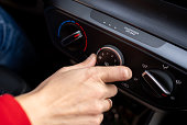Car driver turning on car air conditioning system stock photo