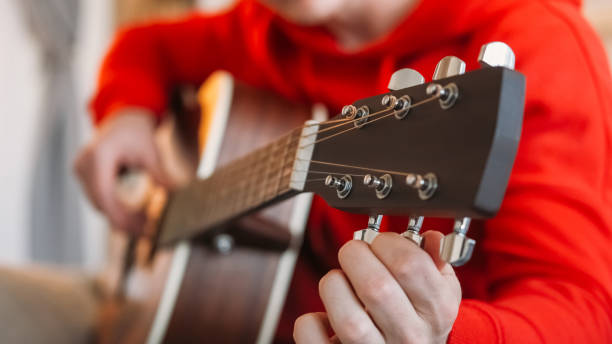 istock Instrument tuning guitarist man hands pegs gears 2060272265
