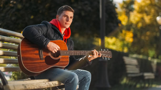 istock Street performance guitar show park man bench 2060272793