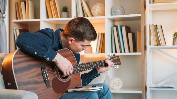 istock Guitar performer songwriter leisure man couch home 2060272843