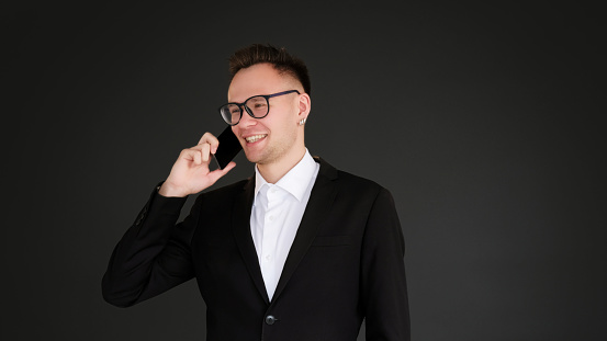 Phone call. Mobile negotiation. Corporate conversation. Smiling business man in suit speaking discussing work isolated on black copy space background.