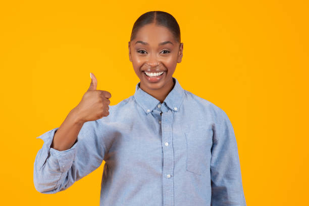 istock Happy black lady giving Thumbs Up gesture over yellow background 2060277893