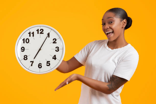 istock Positive Young Black Lady Showing Round Clock To Camera, Studio 2060278427