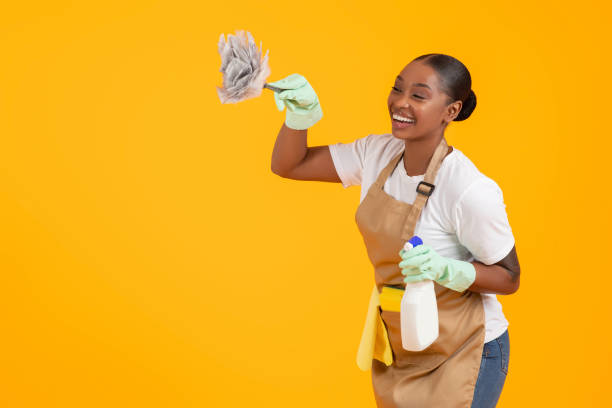 istock professional black cleaner woman dusting copy space over yellow background 2060278435