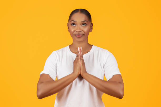 istock Smiling African American Lady Praying Over Yellow Studio Background 2060278476
