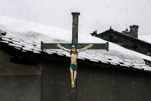 Wooden Christ on a wooden cross in the village Bessans in the French Alps