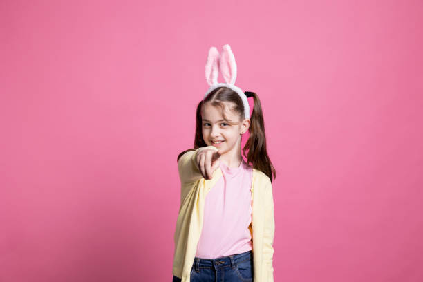 istock Young schoolgirl with pigtails dancing around in pink studio 2060281215