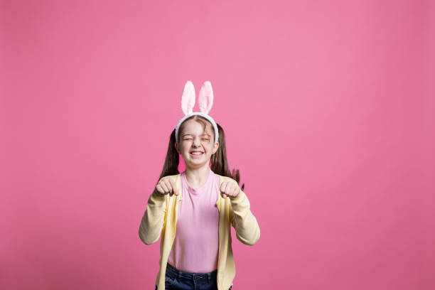 istock Sweet schoolgirl with bunny ears jumping in studio 2060284472