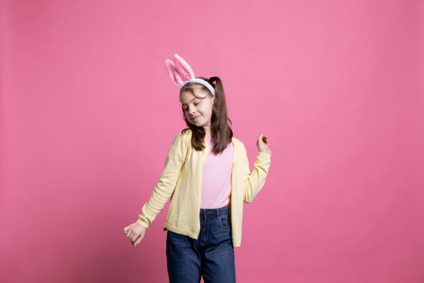 istock Happy cheery junior dancing around in the studio with fluffy bunny ears 2060285025