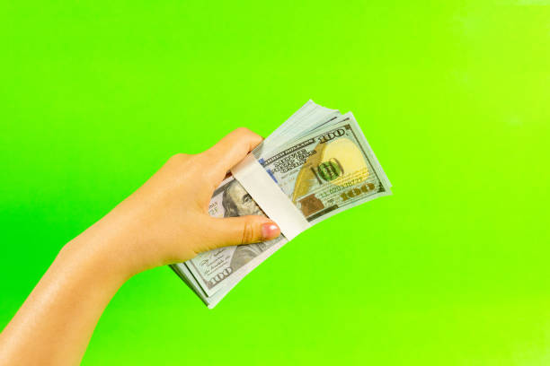Top view of woman hold one hundred dollar bills on color background. Finance concept with copy space, financial income