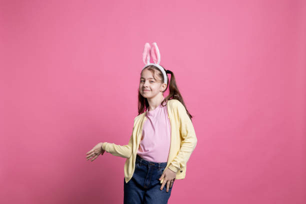 istock Joyful toddler with pigtails and bunny ears dancing on camera 2060287216