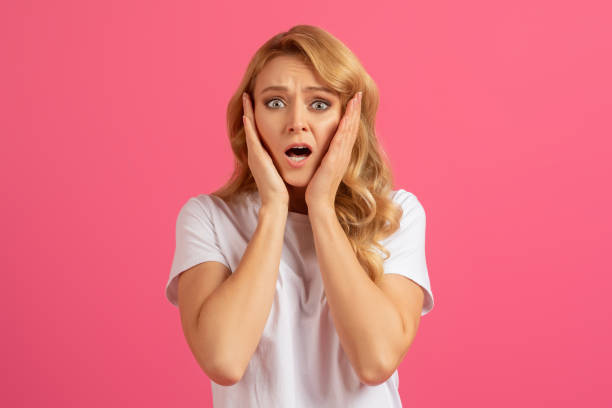 istock Young emotional blonde woman holding her face in shock, studio 2060287256