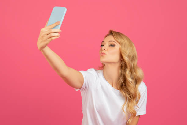 istock Playful Blonde Lady Making Selfie On Phone Pouting Lips, Studio 2060287790