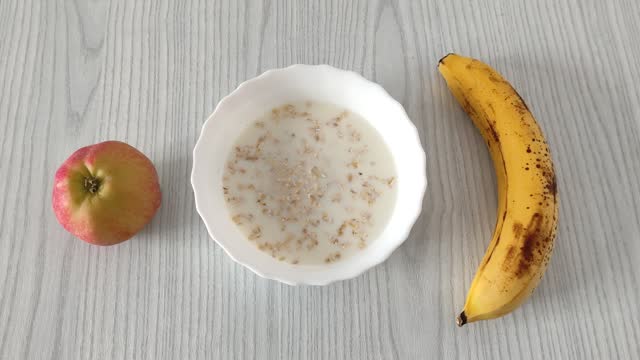 Oatmeal with milk, apple and banana, healthy breakfast